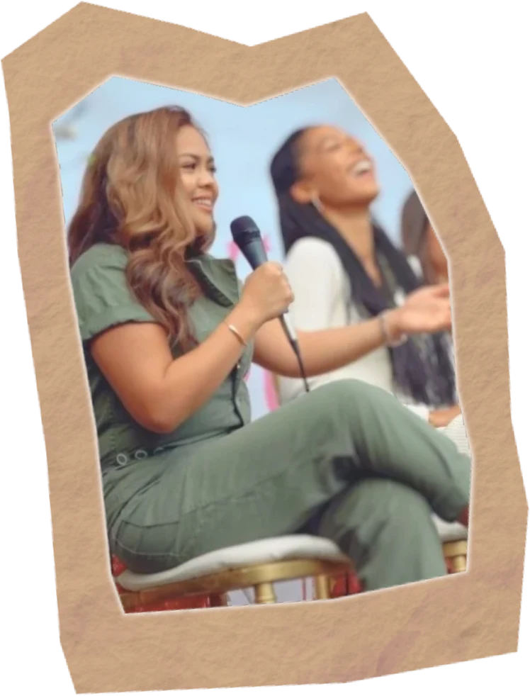 Lissa speaking into a microphone on a panel